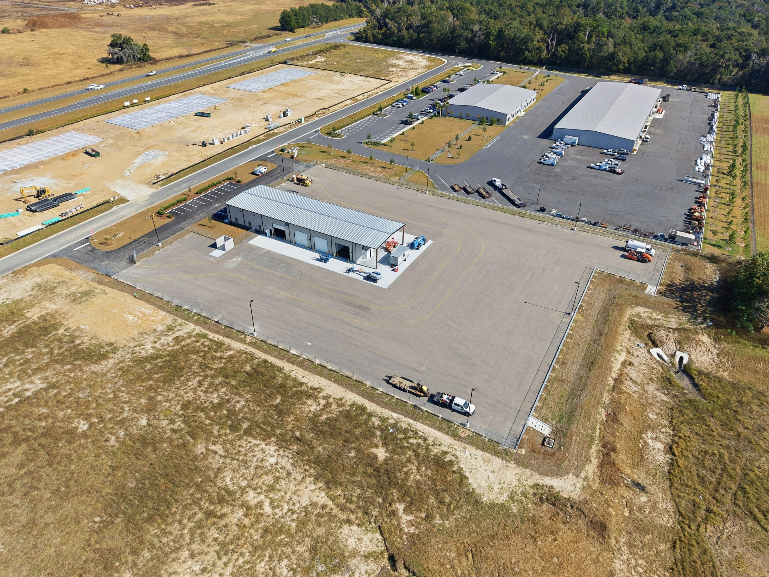 Wide aerial view of completed commercial site development along highway
